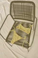 Conjunto de bikini con estampado animal print, compuesto por un corpiño bandeau con breteles finos y una bombacha vedetina con tiras laterales ajustables.