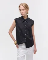 Camisa negra sin mangas en voile de algodón liviano y fresco. Tiene fit relajado, cuello camisero, cartera con botones de nacar y un bolsillo plaqué en delantero. Las sisas están envivadas internamente con una tela contratono. Tiene costura en centro espalda y recorte en cintura trasera con tajo que se superpone. El ruedo es escalonado, más corto adelante. Largo a la cadera.