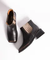 Bota corta negra de cuero con elástico lateral, caña de 12 cm y taco de madera de 4 cm.