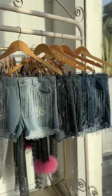 Short de jean elastizado con tiro alto, color negro gastado y flecos de strass.