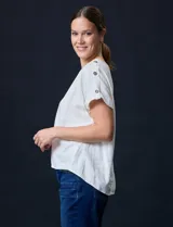 Blusa color blanco de lino marca Cable & Gauge, con aplique de botones en los hombros.