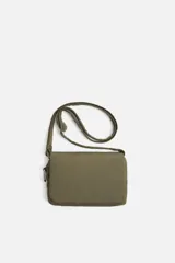 Bandolera de nylon color verde militar, con solapa y cierre magnético. Tiene correa ajustable con mosquetón y un bolsillo interior.