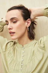 Camisa celeste de manga larga en viscosa suave, con cuello mao y botonadura parcial al frente. El detalle de frunces en los hombros y los puños abotonados le suman delicadeza y estilo.