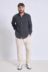 Camisa de manga larga color gris oscuro, con cuello clásico y cierre frontal con botones.