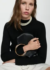 Suéter de punto fino color crudo, con cuello alto y mangas largas.