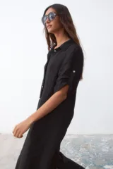 Vestido camisero midi negro de lino con botones blancos y mangas cortas con presilla.