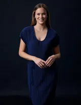 Vestido midi plisado color azul marino, con escote en V y lazo de ajuste en la cintura.