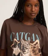 Remera marrón de algodón con cuello redondo y mangas cortas. Estampado frontal con tres gatos y la inscripción "Catgang" y "miaw".