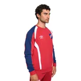 Buzo deportivo Umbro del Club Nacional de Football, color rojo con mangas azul marino y detalles blancos en hombros y laterales. Presenta el logo de Umbro bordado en el pecho y el escudo del club en el lado derecho.