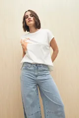 Pantalón de jean negro de corte ancho, tiro medio y cinco bolsillos.