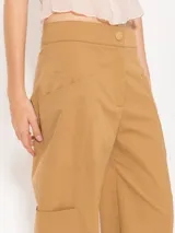 Pantalón cargo color amarillo claro, confeccionado en poplin asargado. Tiene cuatro bolsillos plaqué con refuerzos triangulares en hilo crudo. El ruedo lleva jareta para ajustar y abuchonar con lazo.