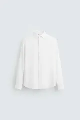 Camisa blanca slim fit de algodón, con cuello italiano, manga larga y cierre frontal con botones.