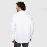 Camisa de lino color gris topo, de corte clásico, con cuello abotonado, manga larga y bolsillo en el pecho.