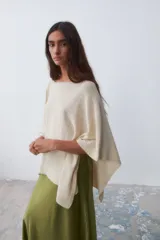 Poncho tejido color crudo, con cuello bote y mangas 3/4.