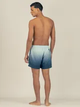 Short de baño con cintura elástica y cordón ajustable, con diseño degradado que va de celeste a azul marino.