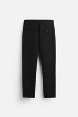 Pantalón slim fit negro confeccionado en tejido con elasticidad en ambas direcciones. Cuenta con bolsillos frontales y traseros de vivo con botón. Cierre frontal con cremallera y botón.
