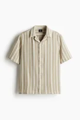 Camisa de manga corta con cuello resort y cierre frontal con botones. Diseño a rayas verticales en tonos beige y blanco.