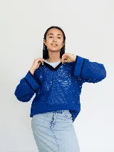 Buzo azul de tejido calado con cuello polo y detalles en negro. Diseño oversized.