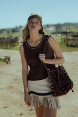 Minifalda marrón de cuero ovino con flecos y cierre frontal.