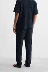 Pantalón azul marino de corte relaxed fit, confeccionado en tejido con mezcla de algodón. Presenta cintura elástica ajustable con cordón, bolsillos frontales y detalle de bolsillo trasero de plastrón.