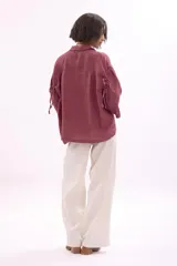 Camisa holgada de lino color rosado, con cuello camisero, manga 3/4 y botones frontales.