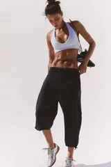 Pantalón deportivo negro, estilo jogger cropped, de silueta relajada y tiro alto con cintura elastizada y cordón ajustable.