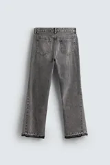 Pantalón de jean celeste de corte flare, con cinco bolsillos, efecto lavado y bajo con acabado irregular.