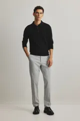 Pantalón de vestir gris claro, de corte slim fit, con pliegues frontales, bolsillos laterales y traseros ribeteados con botón.