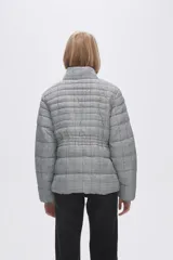 Campera puffer estampada a cuadros en blanco y negro con pequeños corazones rosados, cierre frontal con cremallera y bolsillos laterales.