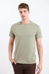Remera verde de manga corta con cuello redondo y logo pequeño bordado en el pecho.