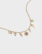 Collar corto dorado con cadena de eslabones y múltiples dijes de mariposa, cuentas de cerámica, rosa, corazón con rosa, perla y moño.