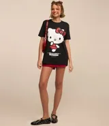 Remera negra de algodón con cuello redondo y mangas cortas. Estampado frontal de Hello Kitty vestida como una estrella de rock.