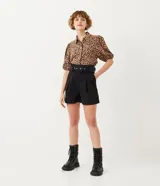Short negro de sarga con cintura alta, trabillas, cierre con botón y cremallera, bolsillos, pliegues delanteros y cinturón con hebilla de corazón.
