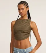 Crop top de encaje color verde militar, con cuello halter y espalda descubierta.