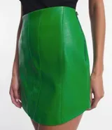 Minifalda negra de cuero sintético con recortes verticales estilo corset y cierre lateral.