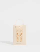 Set de tres pares de aros dorados bañados en oro con circonitas cúbicas. Incluye un par de aros tipo solitario, un par de aros colgantes con tres circonitas y un par de aros tipo argolla.