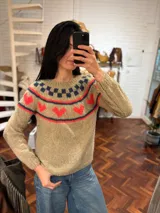 Sweater de punto color gris con diseño de corazones rosas y cuello con diseño geométrico.