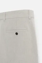 Pantalón de vestir gris oscuro, corte slim fit, con bolsillos laterales y traseros con botón.