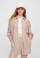 Camisa de lino negra con cuello clásico, manga larga y cierre frontal con botones blancos.