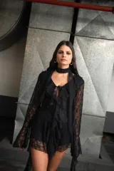 Vestido corto negro de encaje con volados y mangas largas acampanadas.