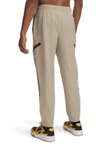 Pantalón de jogging Under Armour para hombre, color beige, con corte ajustado, cintura elástica, bolsillos laterales con cierre y bolsillos cargo con solapa. Logo de la marca en la cadera izquierda. Confeccionado en tejido técnico resistente al agua y elástico.