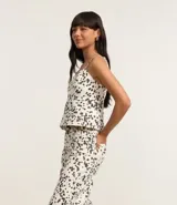 Pantalón wide leg de sarga con estampado animal print dálmata, trabillas en la cintura, cierre con botón y cremallera, y bolsillos delanteros y traseros.