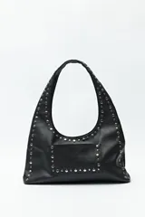 Cartera negra tipo hobo de cuero sintético con apliques de tachas metálicas plateadas en el frente y los bordes.