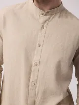 Camisa de manga larga color crudo, confeccionada en lino. Presenta cuello mao y cierre frontal con botones. Marca La Dolphina.