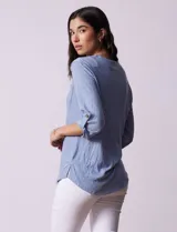 Blusa celeste texturada marca Ninety, con cuello a la base, escote en V y abertura central con botones. Delantera con bolsillo y mangas tres cuartos regulables con presilla y botón.