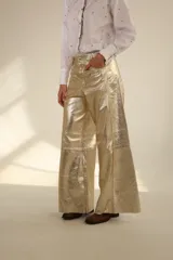 Pantalón dorado de cuero sintético, corte wide leg y tiro alto.
