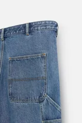 Pantalón de jean negro, corte relaxed fit, con bolsillos frontales y traseros tipo parche, tira multifunción y bolsillo tipo parche en las piernas. Tiene efecto lavado y cierre frontal con cremallera y botón.