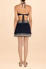 Minifalda azul marino con estampado floral dorado, corte asimétrico y lazo lateral.