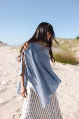 Poncho celeste tejido en lino con lurex, corte oversize.