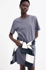 Vestido corto tipo remerón en punto de algodón color gris. Modelo con cuello redondo, hombros caídos y bajo recto.